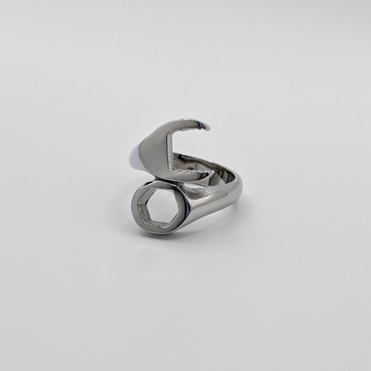 A stainless steel wrench-shaped ring on a plain background.