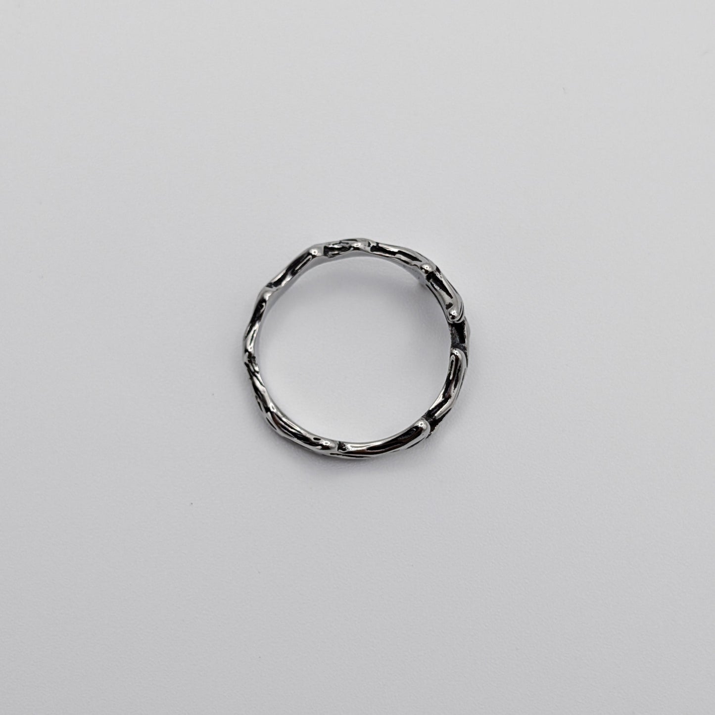 Top-view of a stainless steel ring with a design resembling antlers.