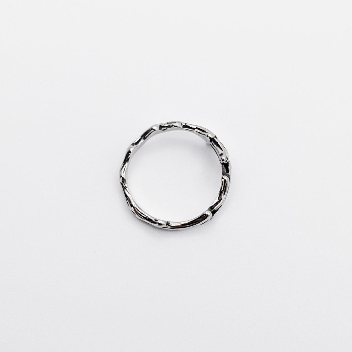 Top-view of a stainless steel ring with a design resembling antlers.