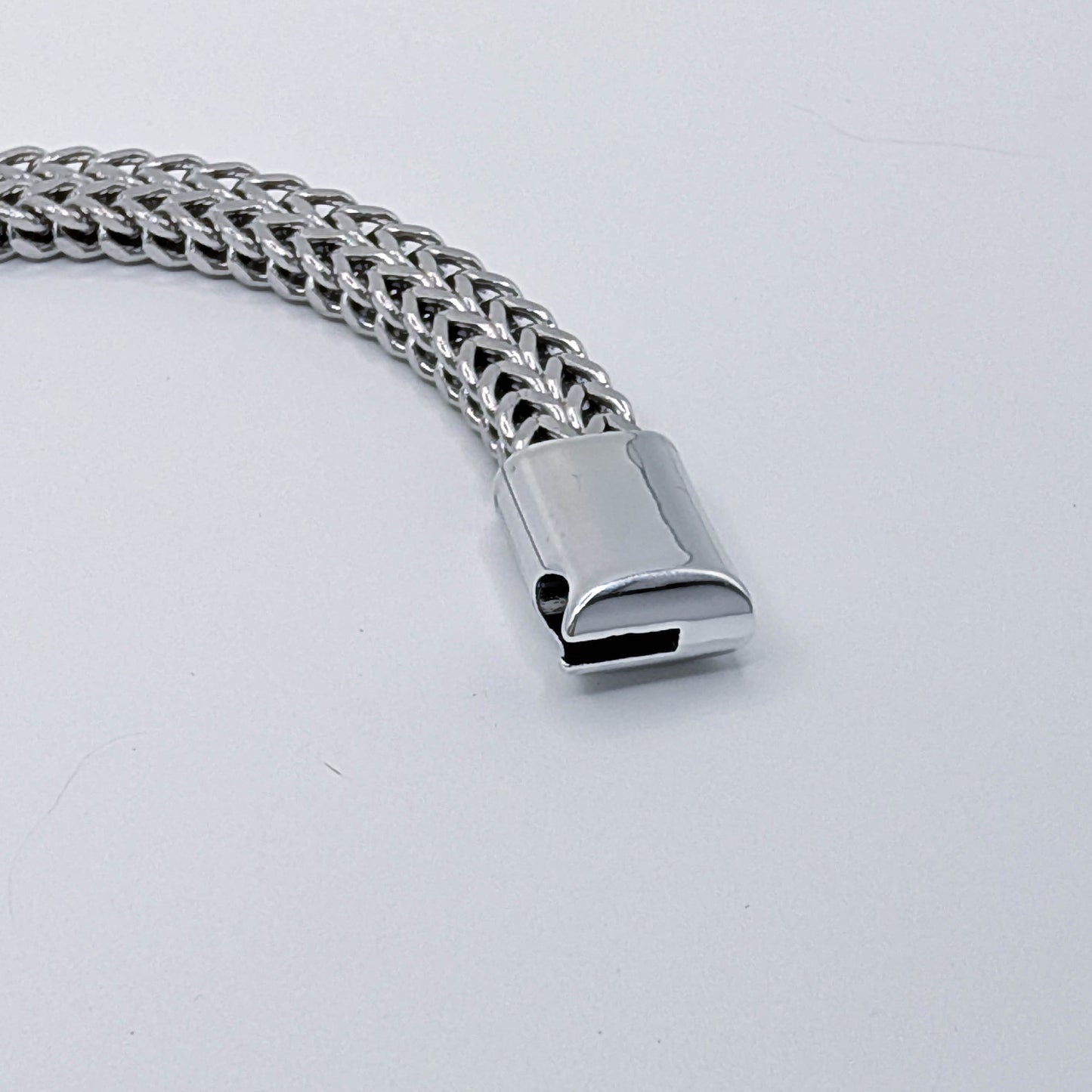 Close up of the clasp on the thick stainless steel men's cuban link style bracelet.