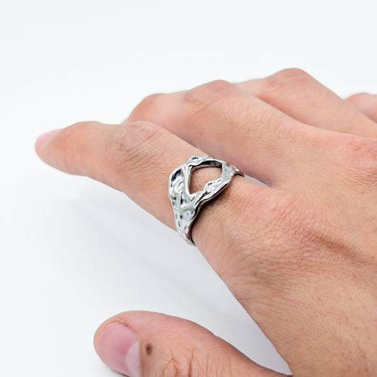 Close-up of the textured stainless steel ring with an open cutouts on a model.