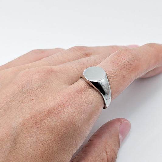 Close-up of a classic silver oval ring worn by a model.
