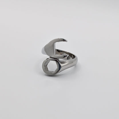 A stainless steel wrench-shaped ring on a plain background.