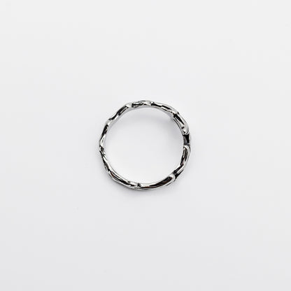 Top-view of a stainless steel ring with a design resembling antlers.