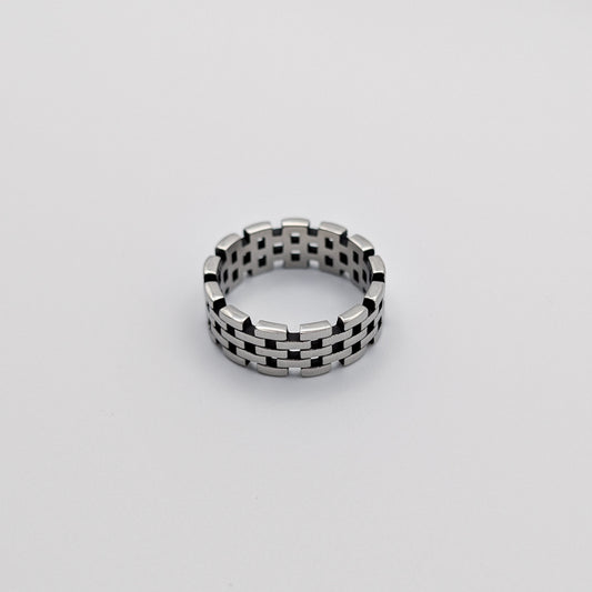 A hollow chain stainless steel ring with a black and white patterned band, displayed against a white background.