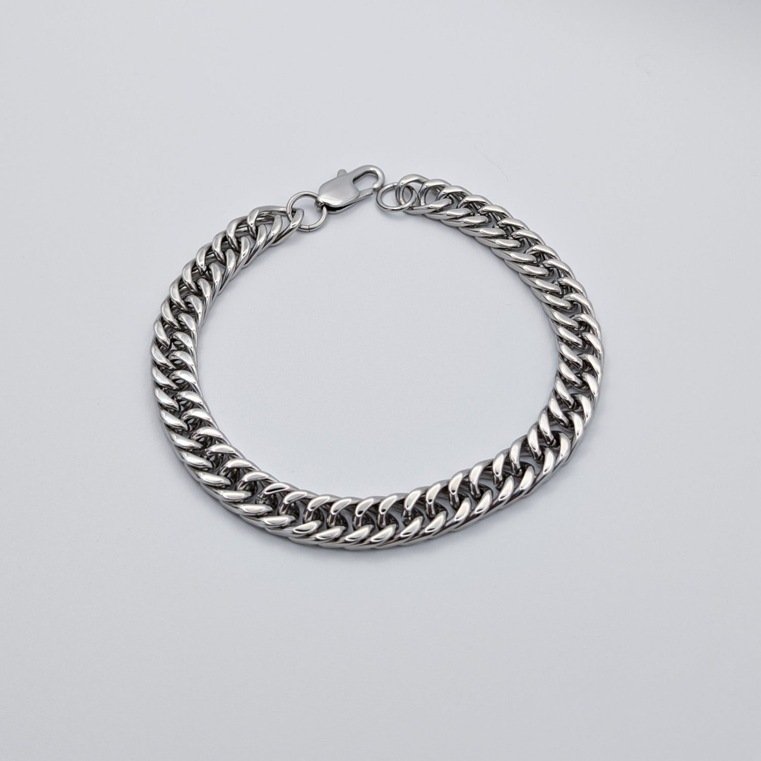 Polished Cuban link style bracelet made from stainless steel featuring a lobster clasp.