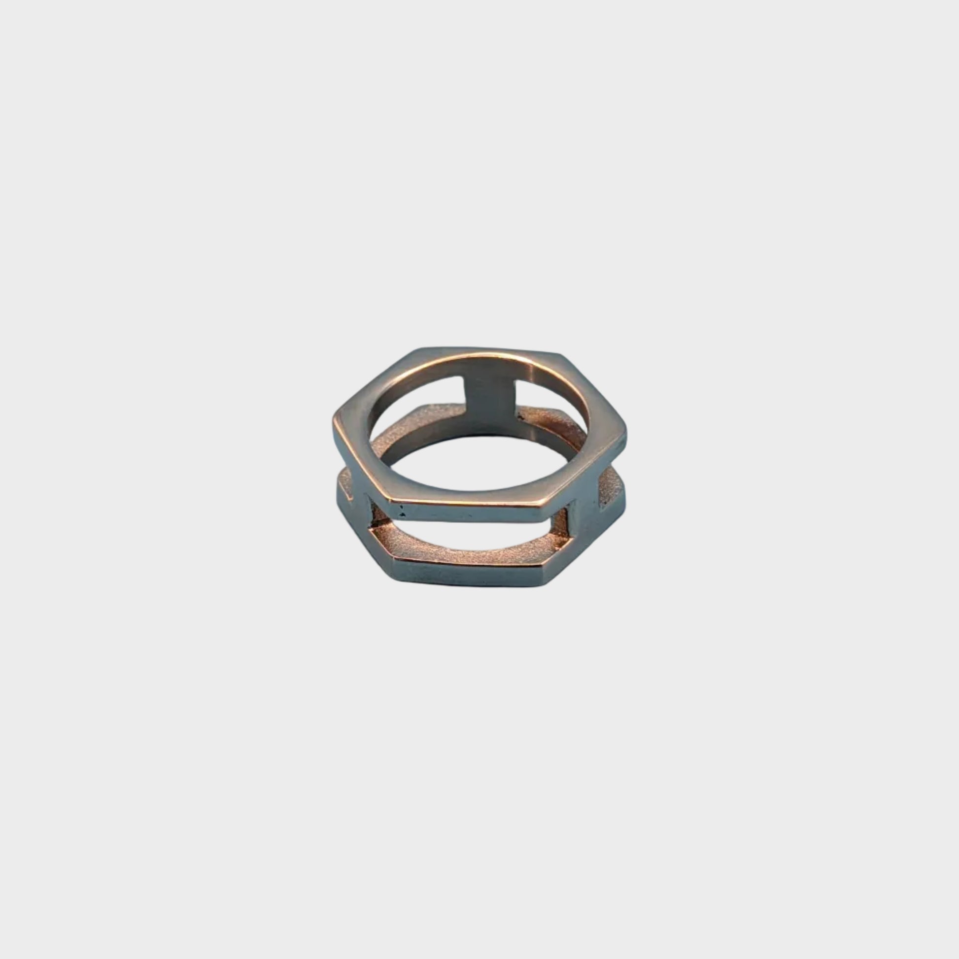 A hexagonal metal ring with a geometric openwork design, featuring a silver-toned exterior.