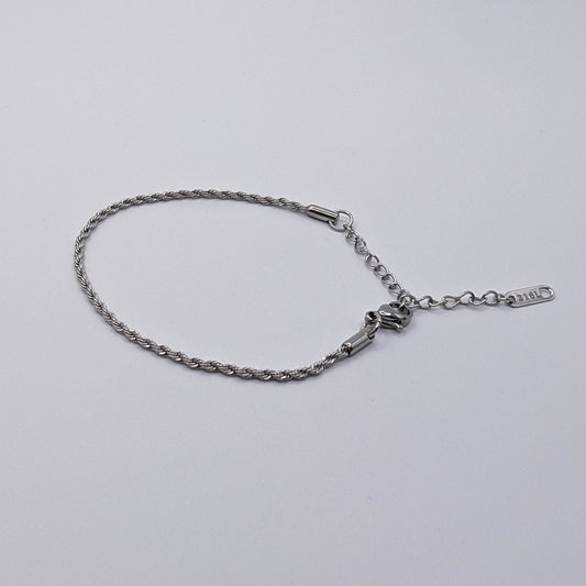 Silver stainless steel bracelet on a light gray background.