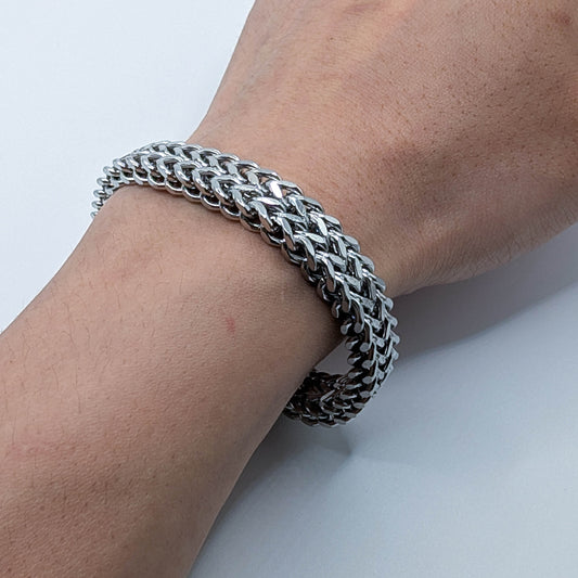 Close up of a model's wrist wearing the thick stainless steel men's cuban link style bracelet.