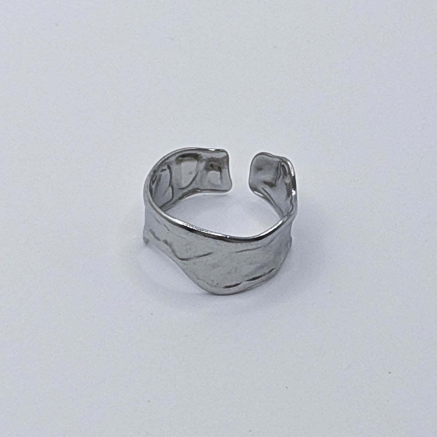 Modern stainless steel ring with organic design and open back.