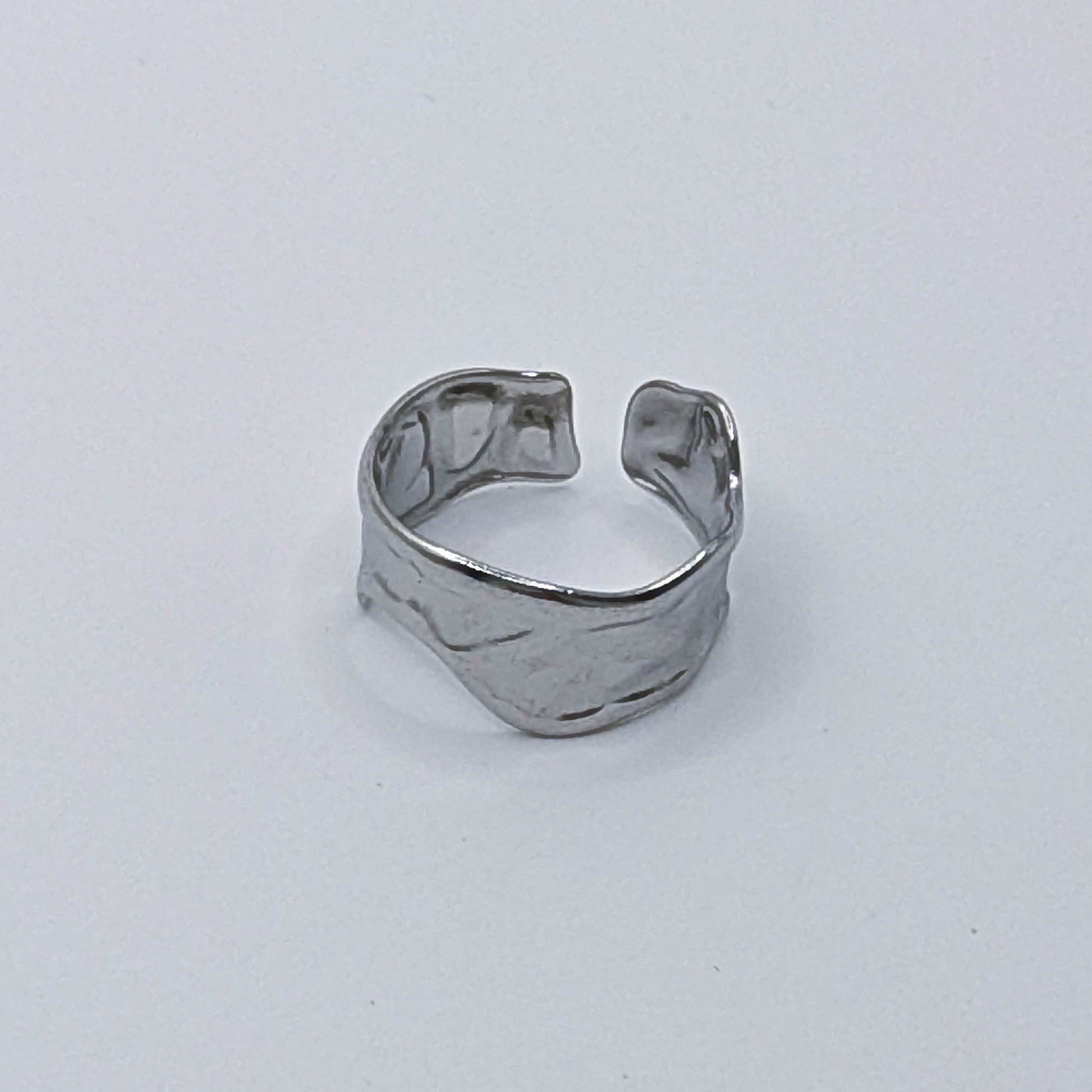 Modern stainless steel ring with organic design and open back.
