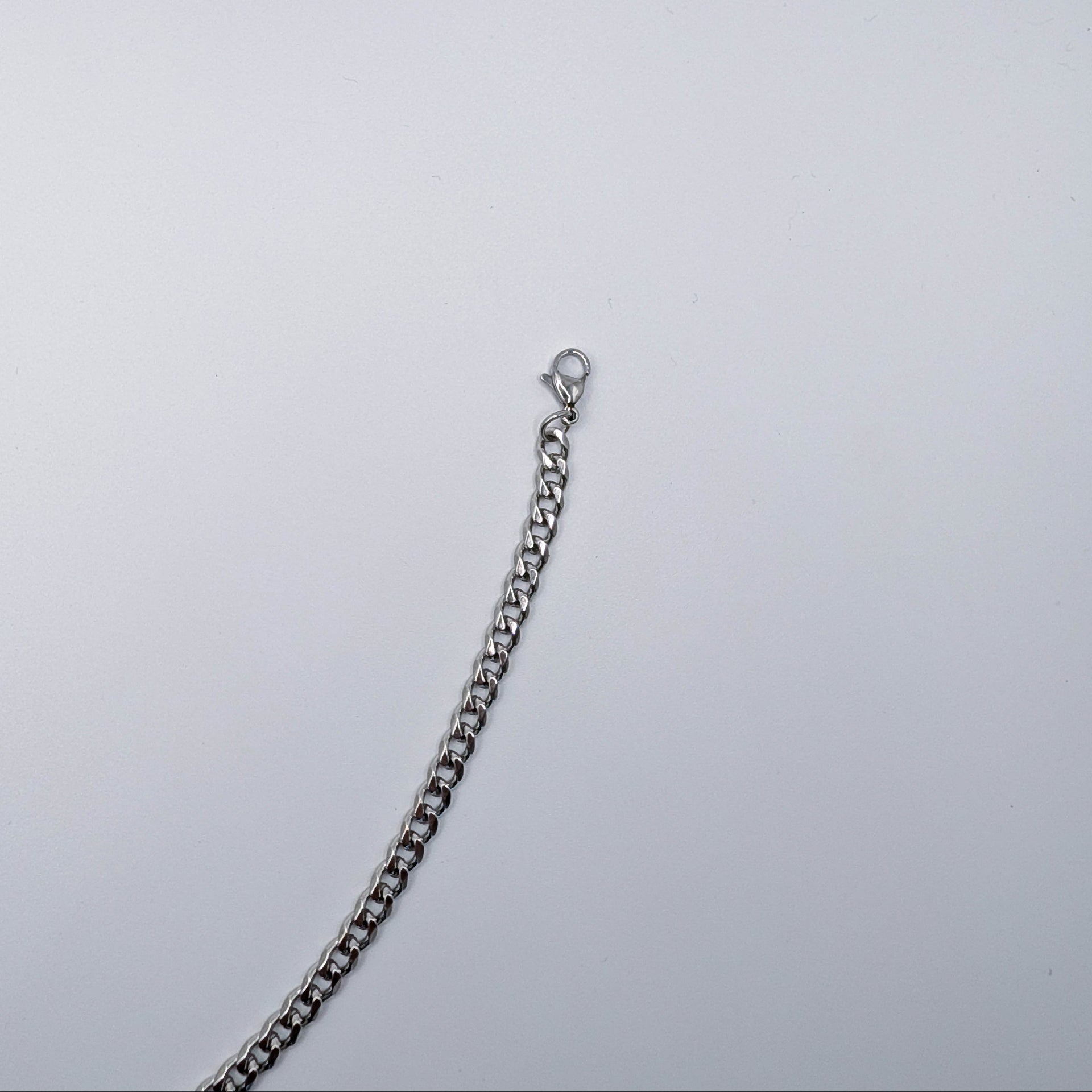 Close up of the stainless steel cuban link style chain bracelet, showing the clasp.