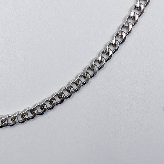 Close up of stainless steel cuban link style chain bracelet, showing the details of the chain.