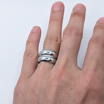 Close-up of a modern stainless steel double-layered stack ring worn on a finger, demonstrating a minimalist everyday style.