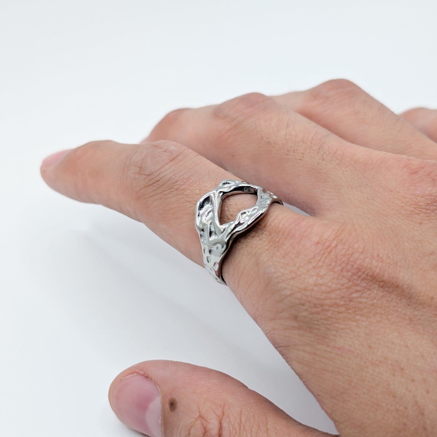 Close-up of the textured stainless steel ring with an open cutouts on a model.