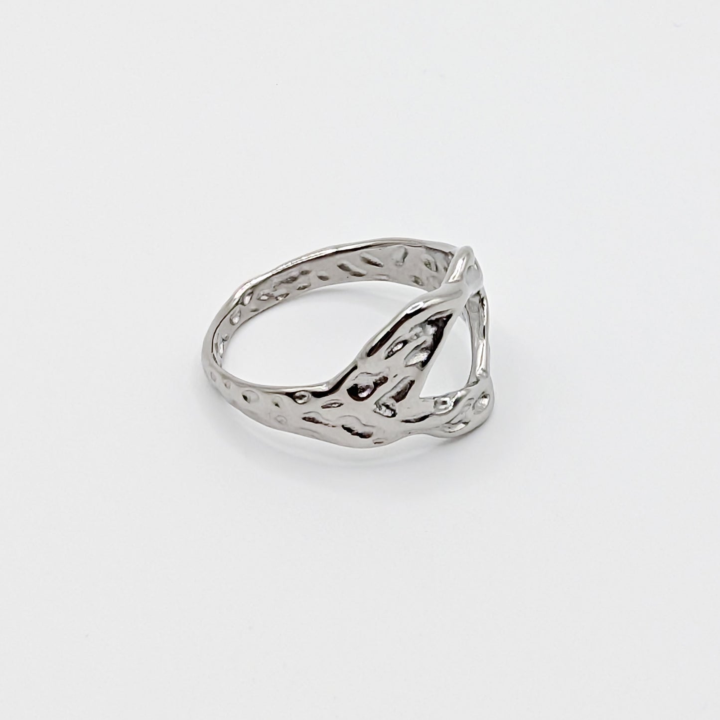 Textured stainless steel ring with an open cutouts on a white background in different orientation.