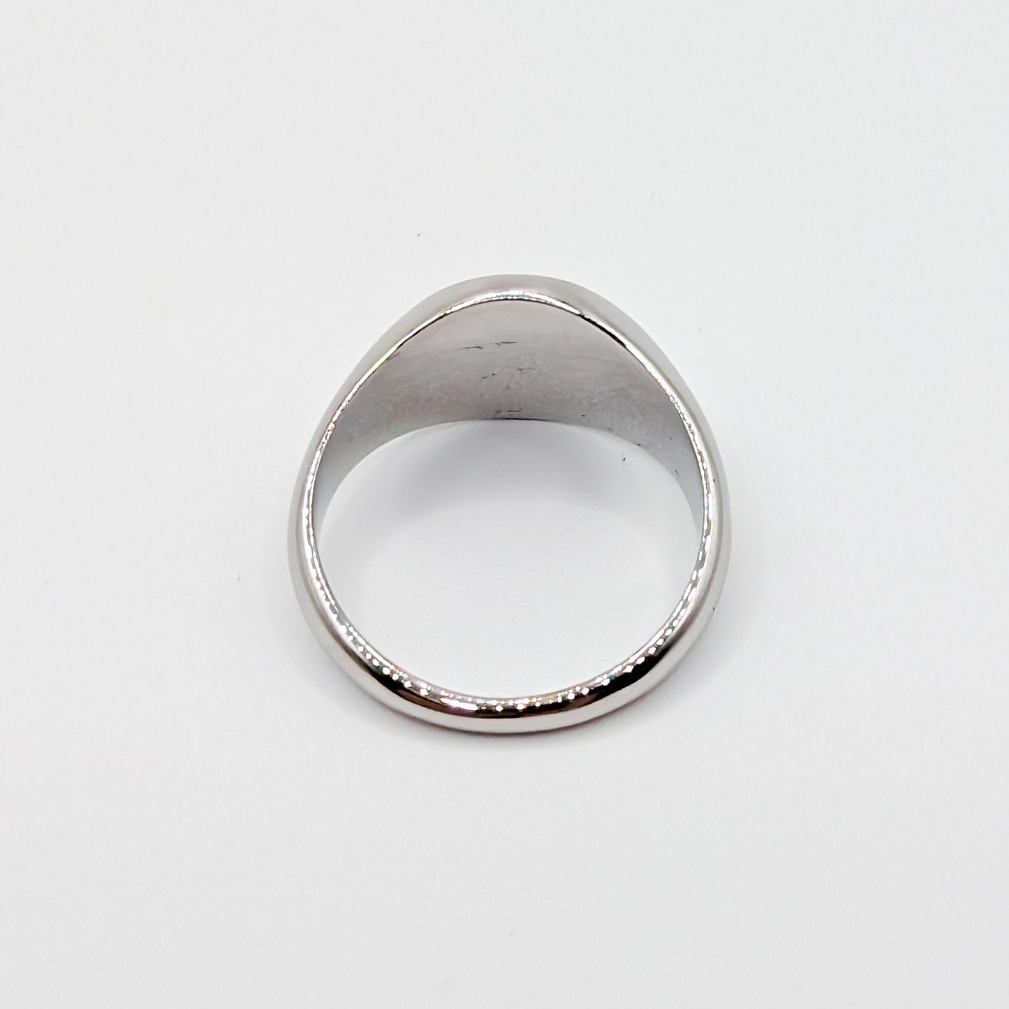 Top down view of a silver steel signet ring.