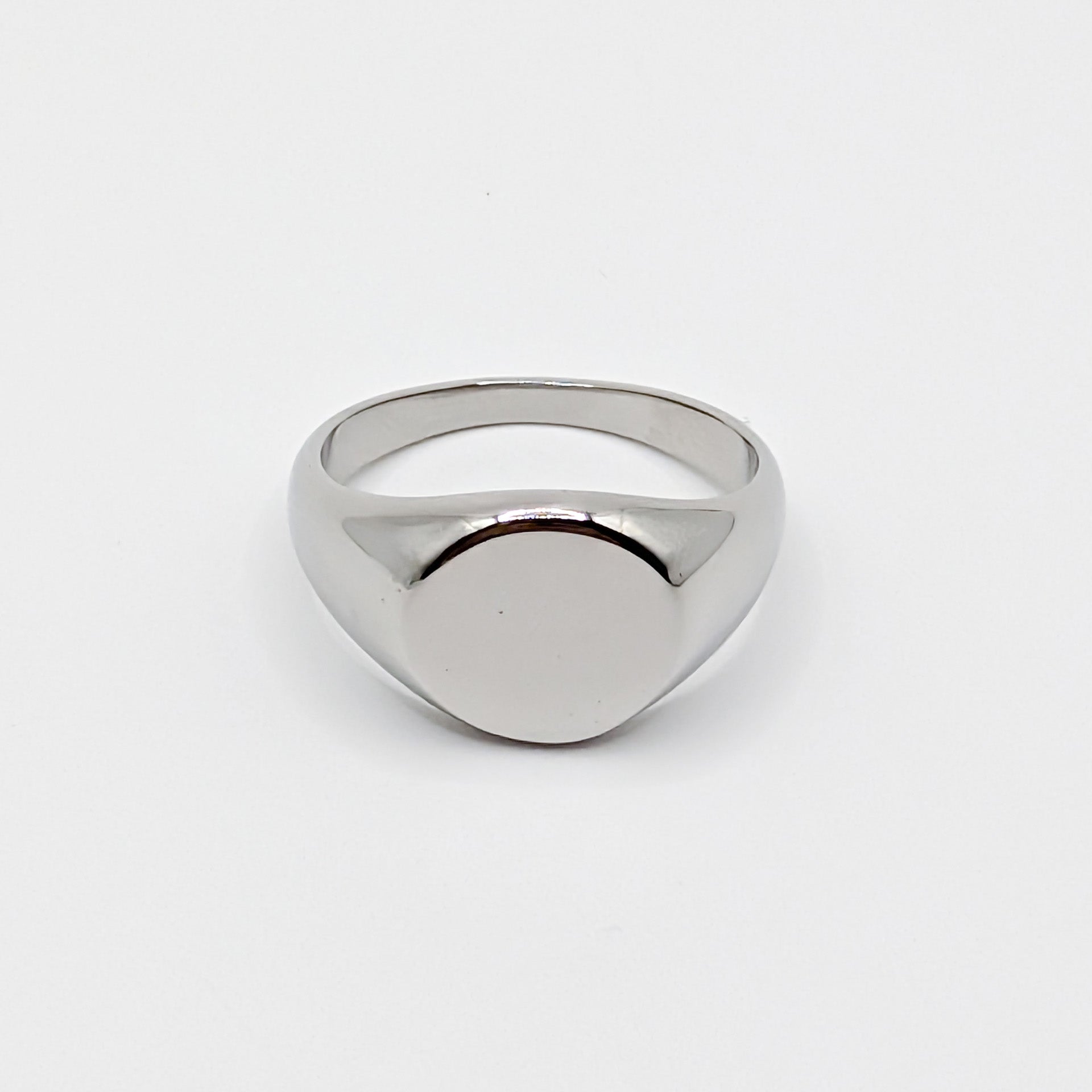 Minimalist polished stainless steel oval signet ring with a smooth blank face on a white background.