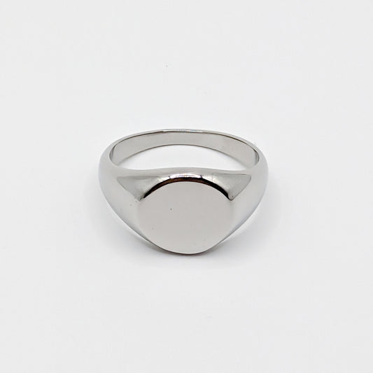 Minimalist polished stainless steel oval signet ring with a smooth blank face on a white background.