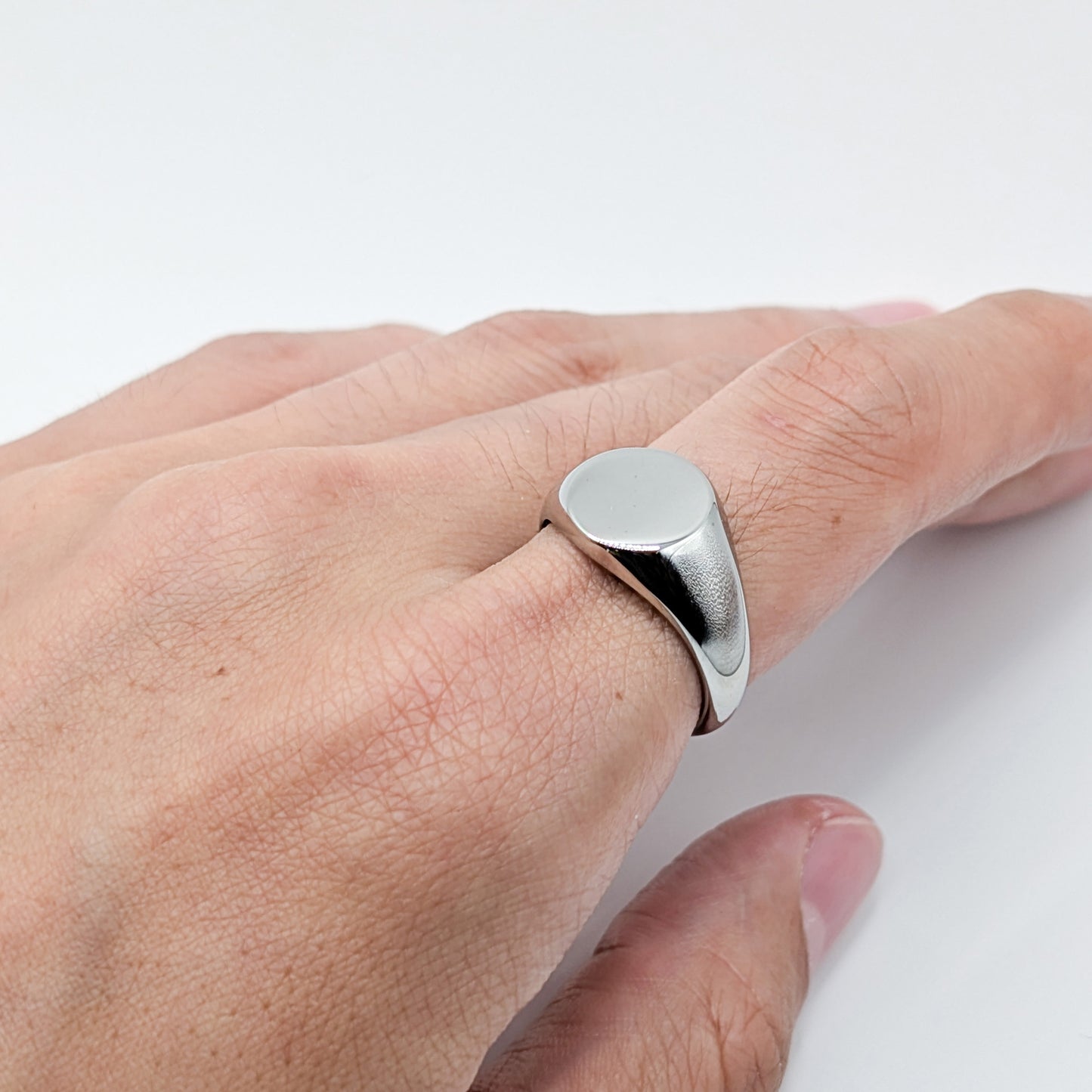 Close-up of a classic silver oval ring worn by a model.