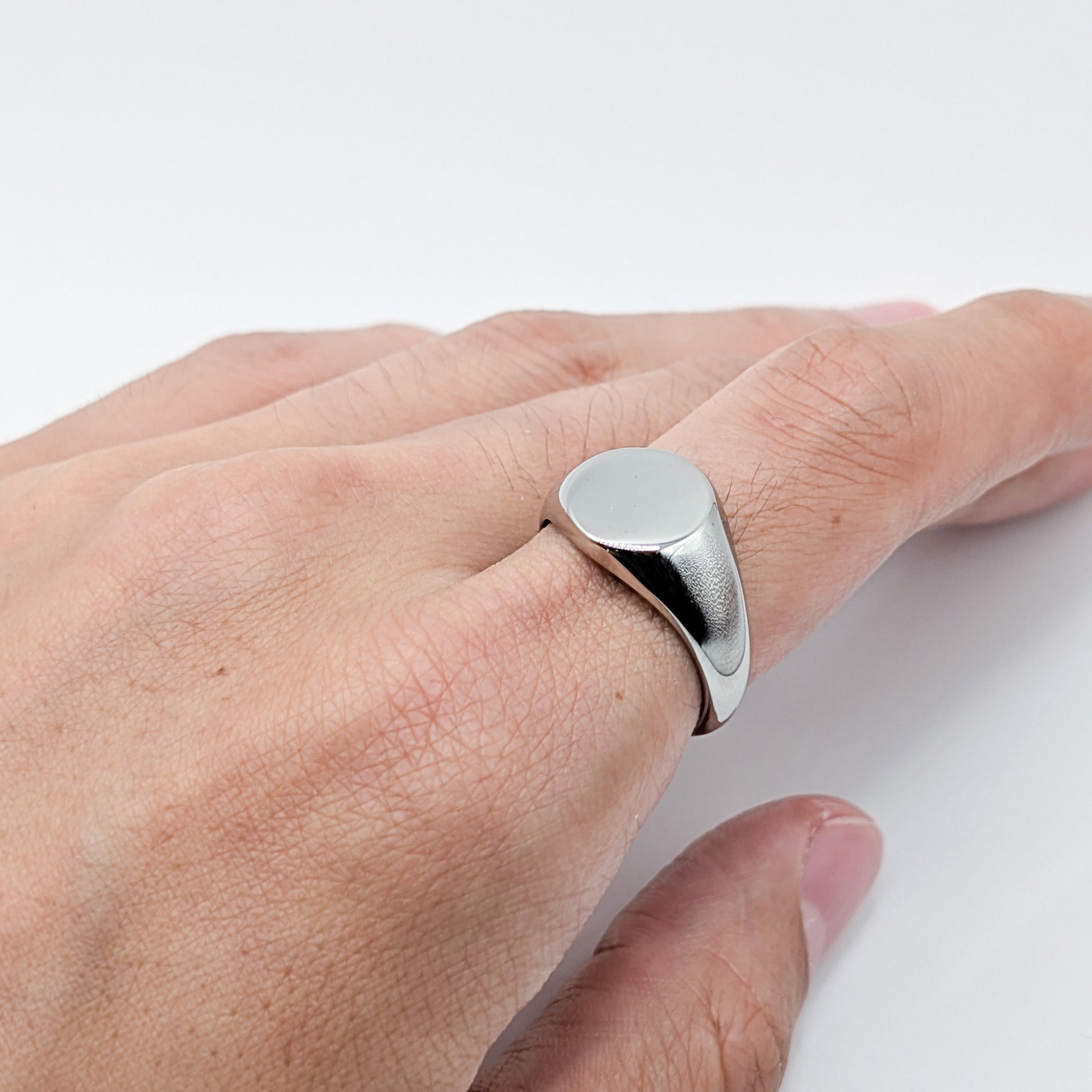 Close-up of a classic silver oval ring worn by a model.