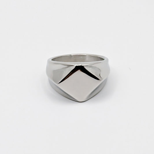 Polished minimalist stainless steel signet ring with a geometric diamond shaped pointed face on a clean white background.
