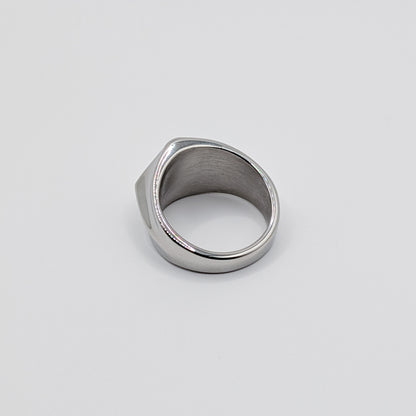 Back view of polished minimalist stainless steel signet ring with a geometric diamond shaped pointed face on a clean white background.
