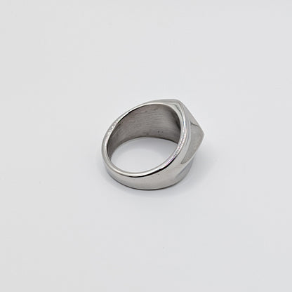 Side view of polished minimalist stainless steel signet ring with a geometric diamond shaped pointed face on a clean white background 