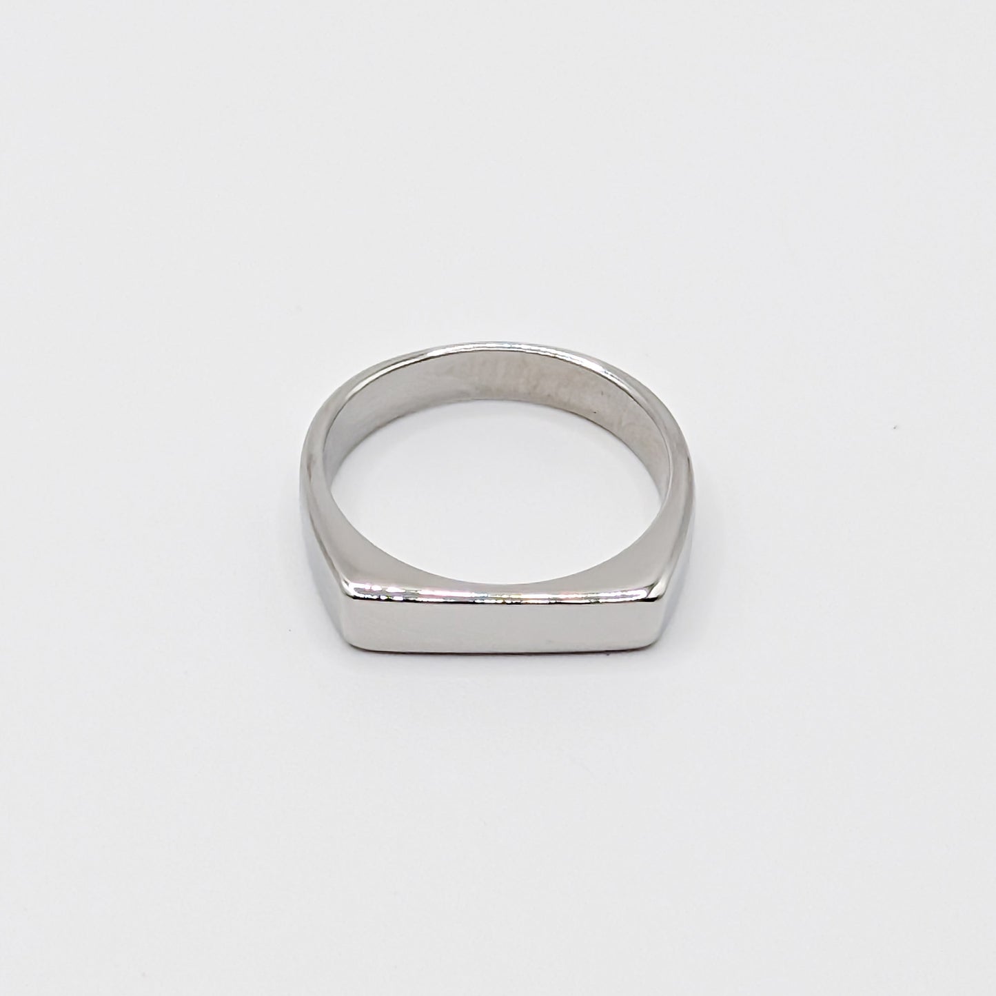 Polished minimalist stainless steel ring with a flat rectangular face on a clean white background.