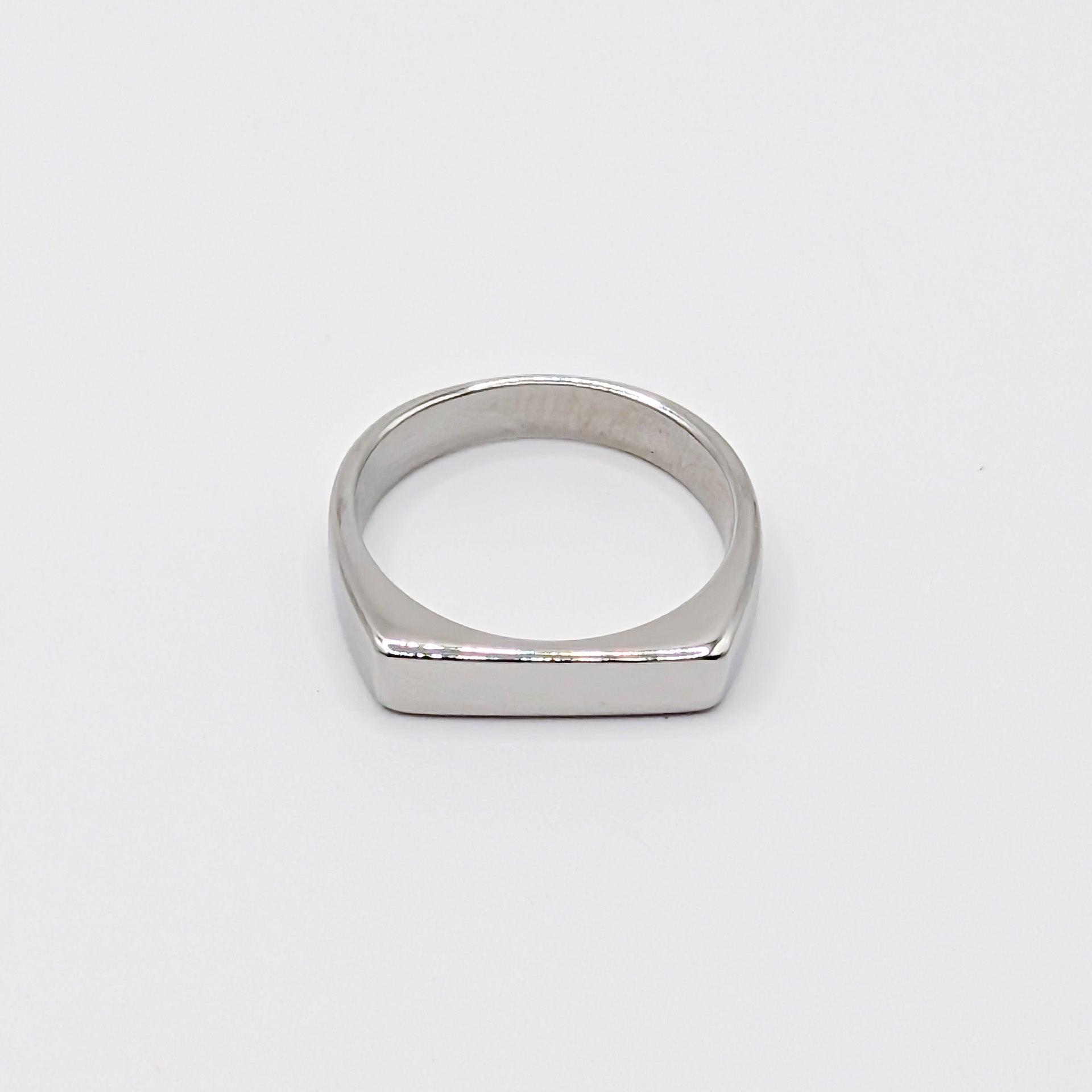 Polished minimalist stainless steel ring with a flat rectangular face on a clean white background.