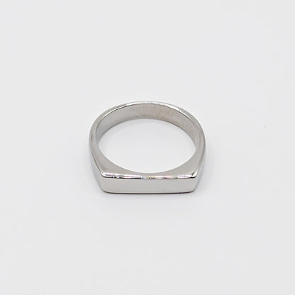 Polished minimalist stainless steel ring with a flat rectangular face on a clean white background.