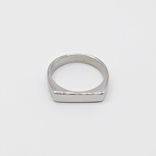 Polished minimalist stainless steel ring with a flat rectangular face on a clean white background.