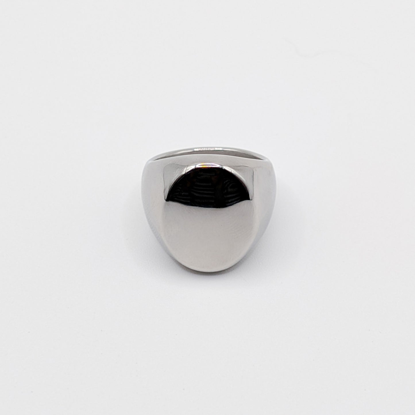 Thick polished minimalist stainless steel signet ring on a white background.