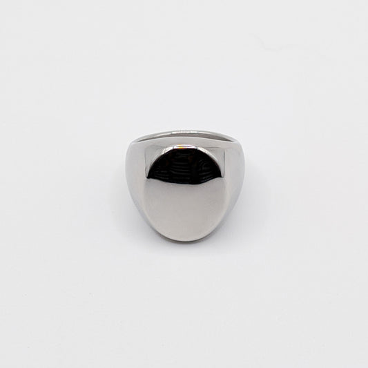 Thick polished minimalist stainless steel signet ring on a white background.
