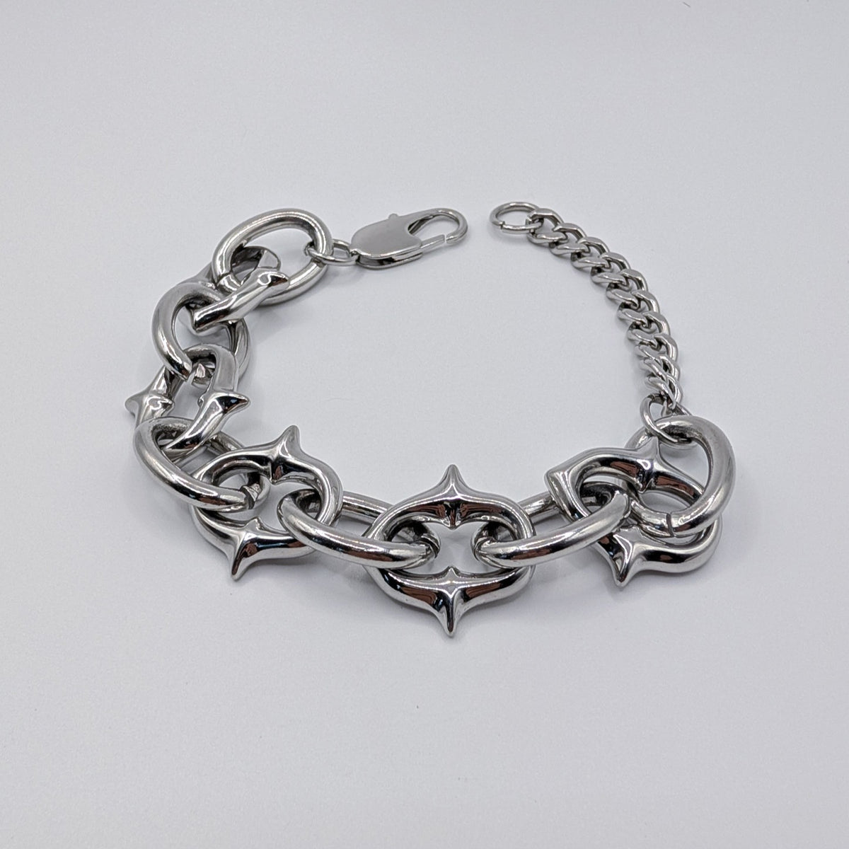 A silver-toned metal chain bracelet with large interlocking links and a lobster clasp, photographed on a plain light background.